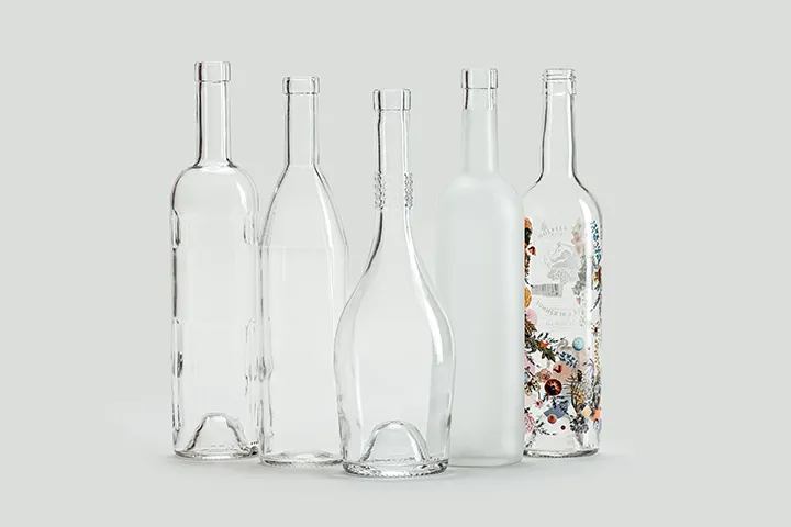 Cinq bouteilles en verre extra-blanc aux finitions transparente, satinée et décorée