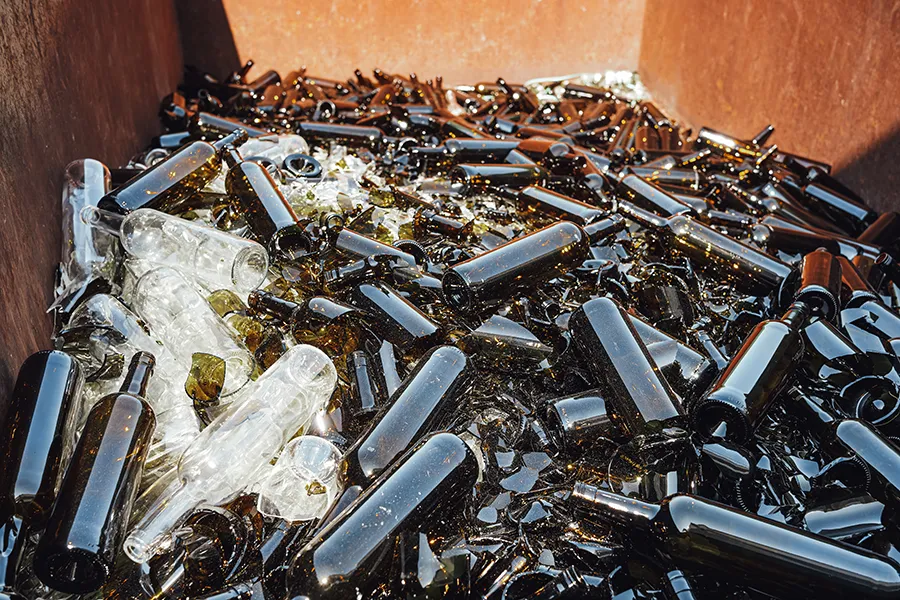 Fragments de verre recyclé (calcin) collectés à la main en vue de leur refonte
